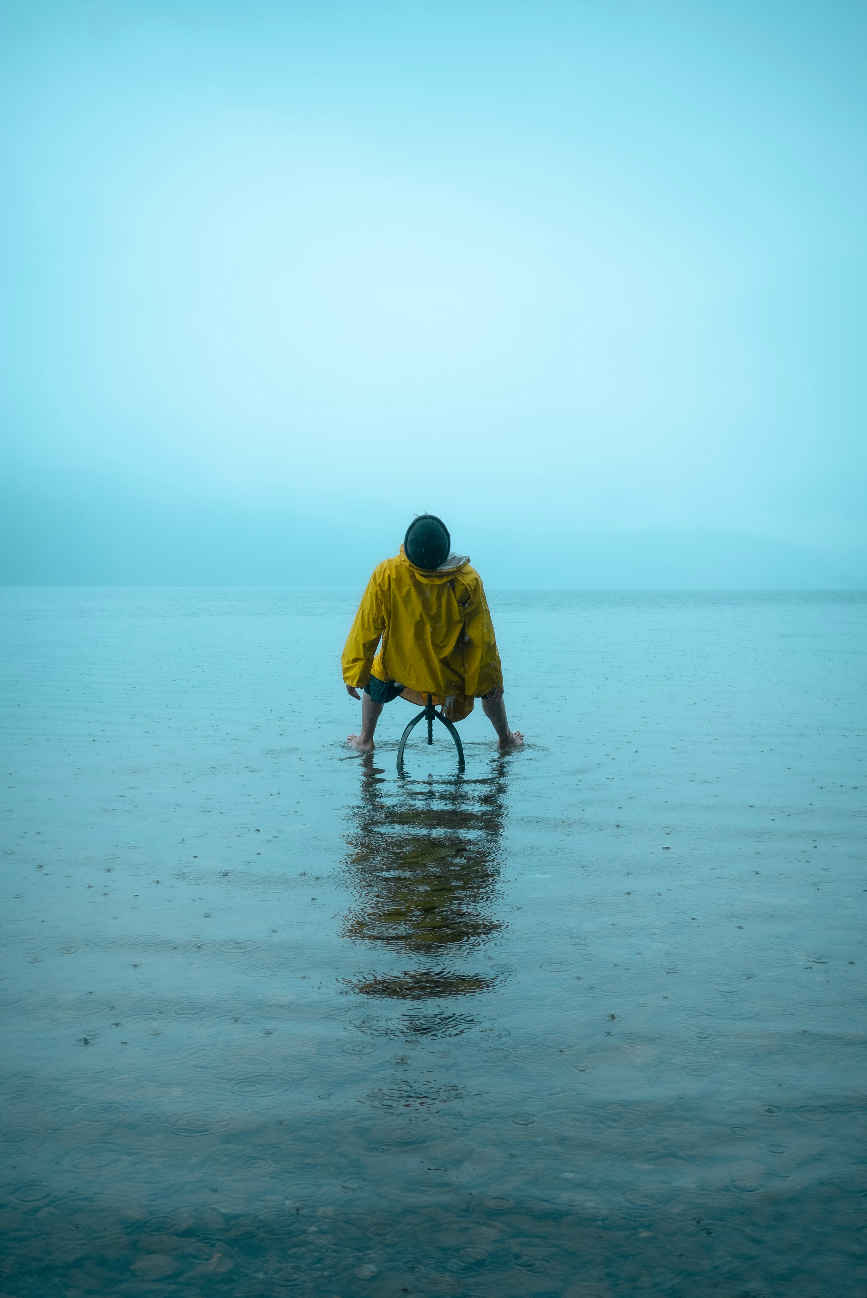 man in yellow hoodie walking on beach during daytime
